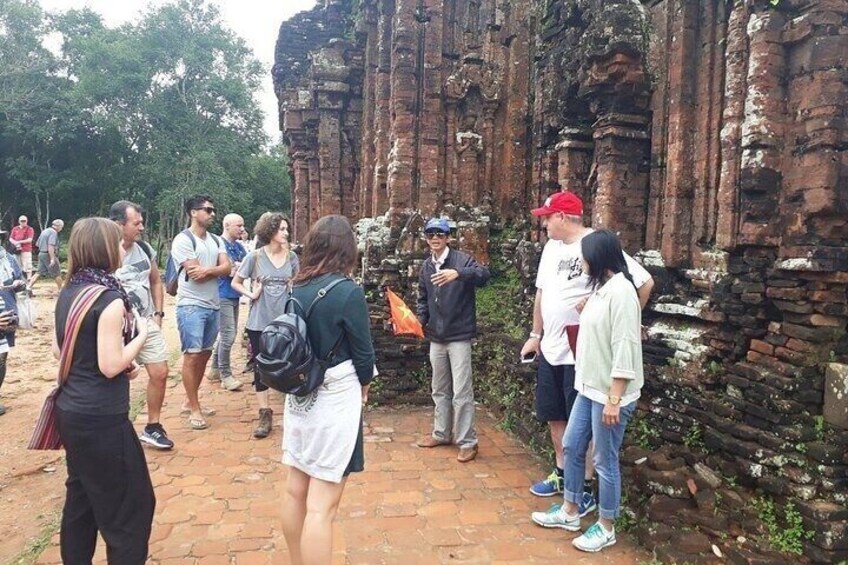 A group of tourists standing near ancient stone ruins. 2