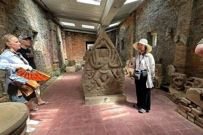 A historical site with stone carvings and a central triangular structure. 5