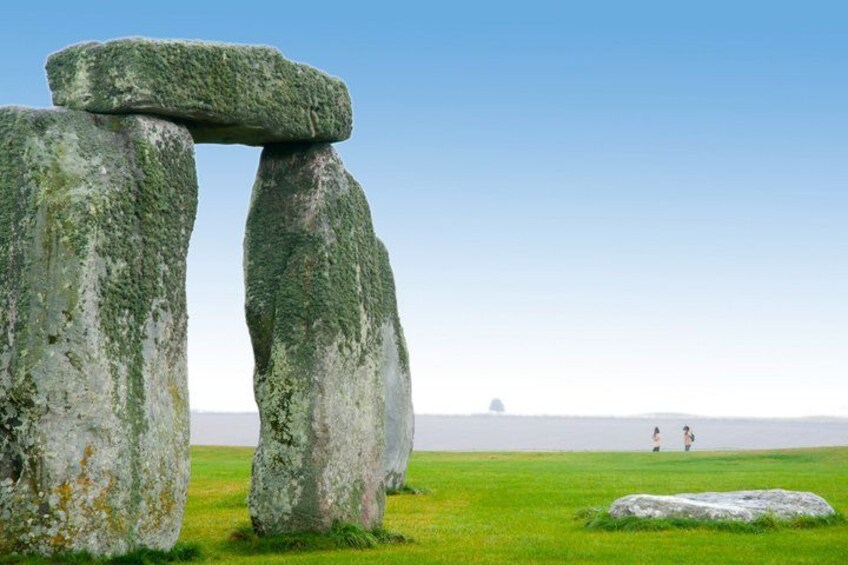 Stonehenge standing in a grassy field with a clear sky. 4