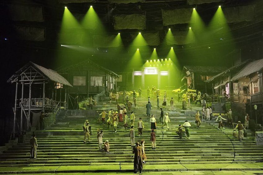 A stage with a crowd of people, a staircase, and a building in the background. 3