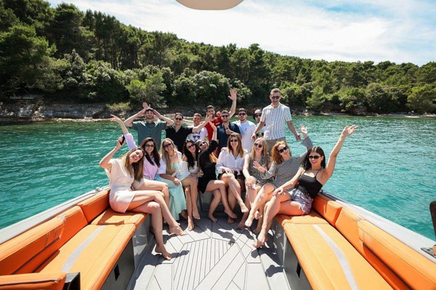 A group of people on a boat with a forested shoreline in the background. 1