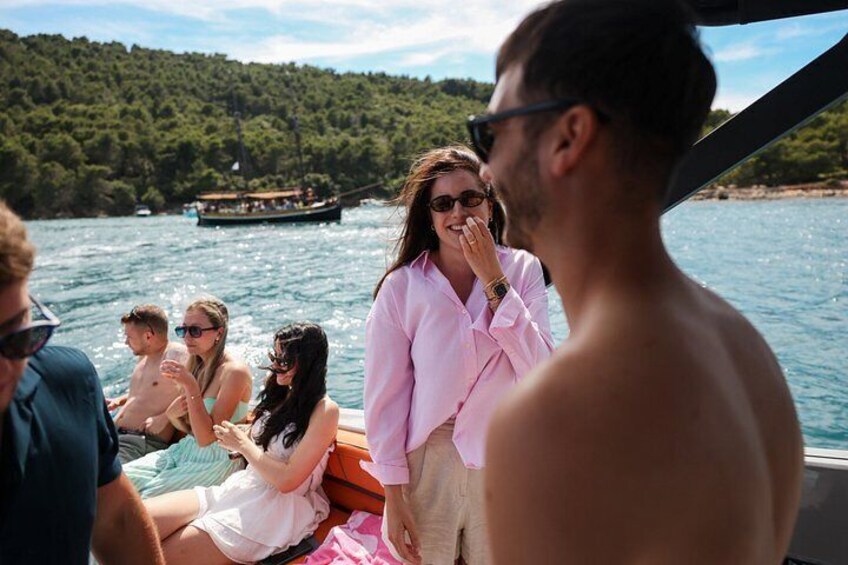 A group of people on a boat with a forested shoreline in the background. 4