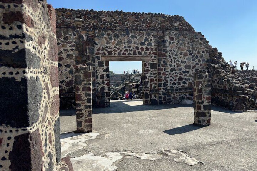 A stone archway with a view of a coastal landscape. 5
