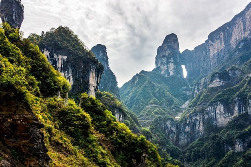 A mountainous landscape with lush greenery and prominent rock formations. 1