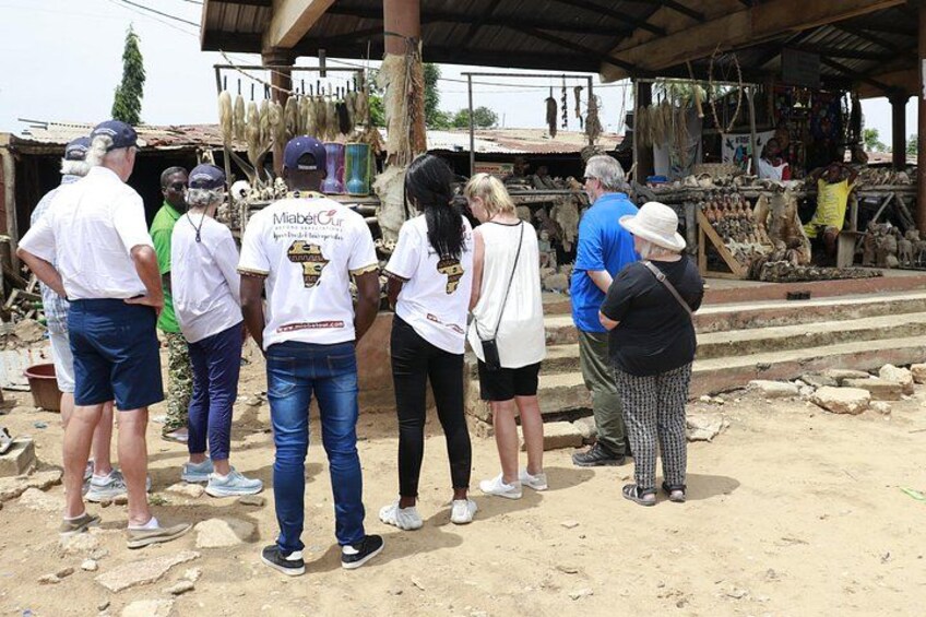 A group of people standing in a market area with a covered structure in the background. 3