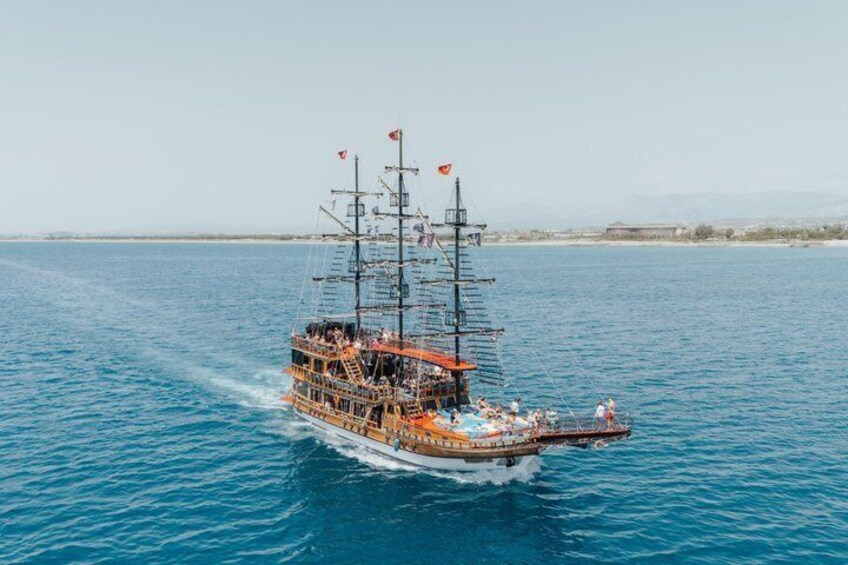 A large sailing ship with multiple masts and flags, sailing on a calm sea. 2