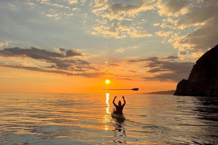 A person kayaking at sunset with a cliff on the right. 4