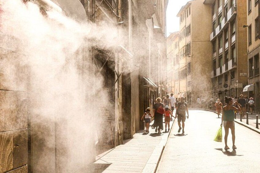 A street with people walking, buildings, and a smoke effect. 5
