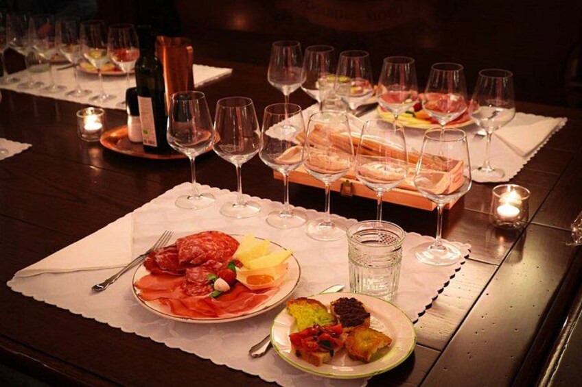A table set for a meal with plates of food, wine glasses, and candles. 4