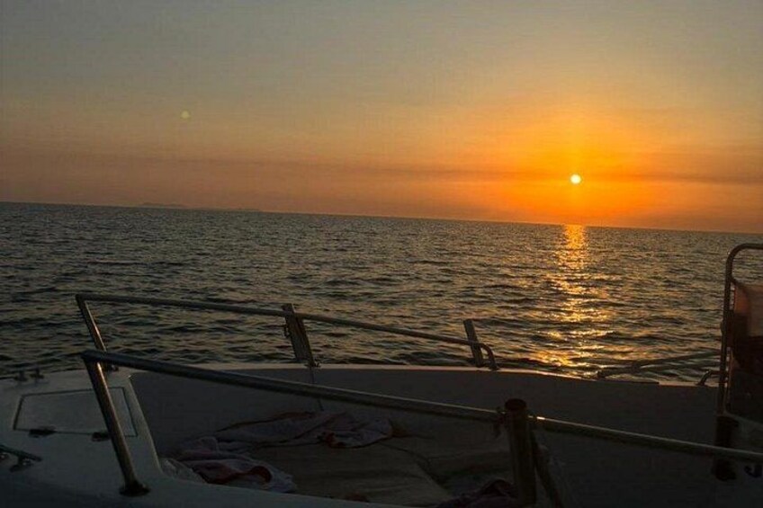 A sunset over the ocean with a boat in the foreground. 2
