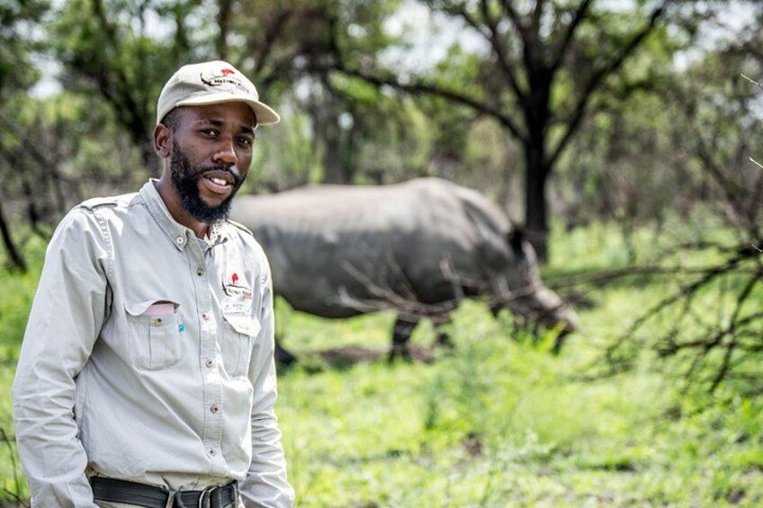 A person in a field with a large animal in the background. 1