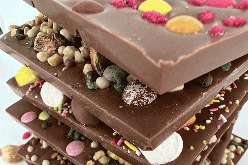 A multi-layered chocolate bar with various candies and sprinkles. 1