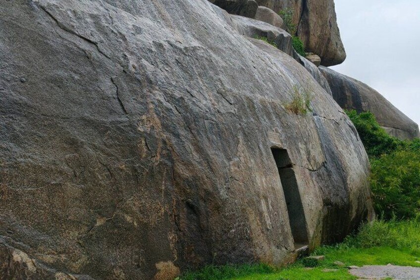 A large rock formation with a cave entrance. 4