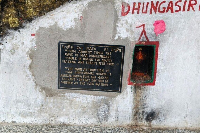 A weathered wall with a historical plaque and graffiti. 3