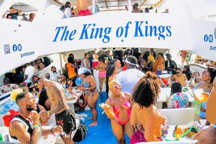 A crowded boat with people enjoying drinks and socializing, labeled 'The King of Kings.' 3