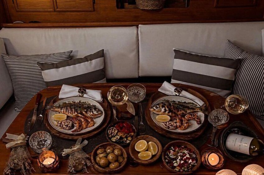A dining table set with seafood, wine glasses, and candles. 3
