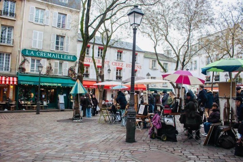 A cobblestone street with outdoor cafes, a market stall, and a building with 'LA CREMAILLERE' signage. 4