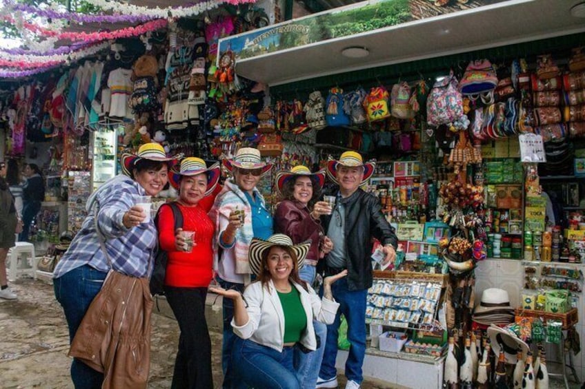 A group of people posing in front of a colorful market stall with various goods. 5