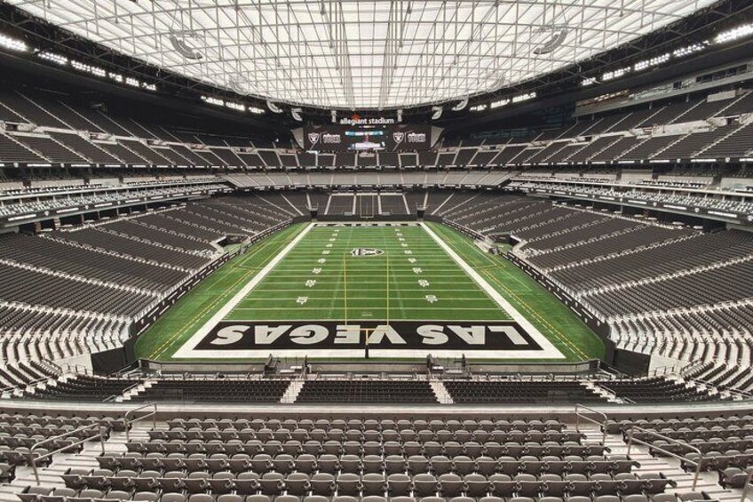 An empty football stadium with a field marked 'LANSING LANS' and tiered seating. 1