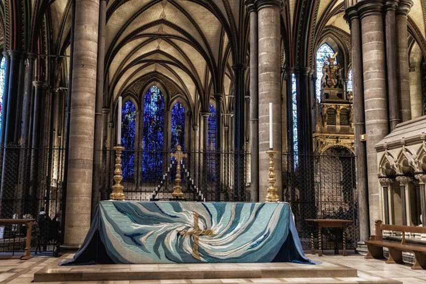 A church interior with Gothic architecture, stained glass windows, and a central altar. 5