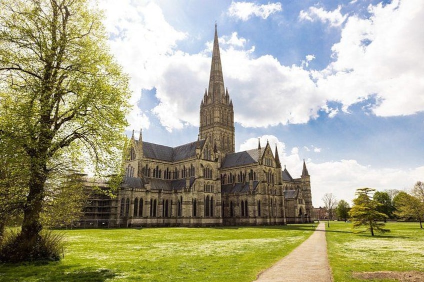 A large Gothic-style church with a tall spire, surrounded by a well-maintained lawn and a pathway leading to the entrance. 1