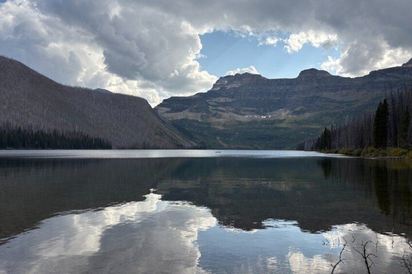 A calm lake surrounded by mountains and dense forests. 3