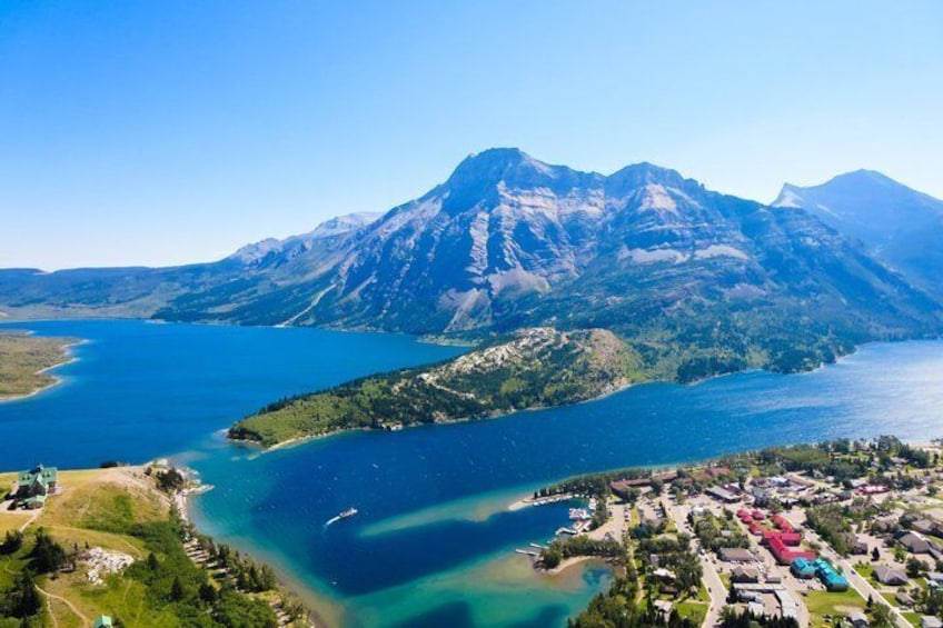 A mountainous landscape with a lake and a small town. 1