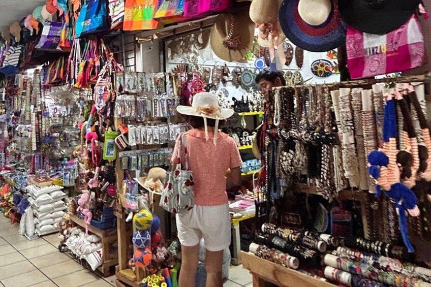 A market stall with various items on display including hats, bags, and jewelry. 3