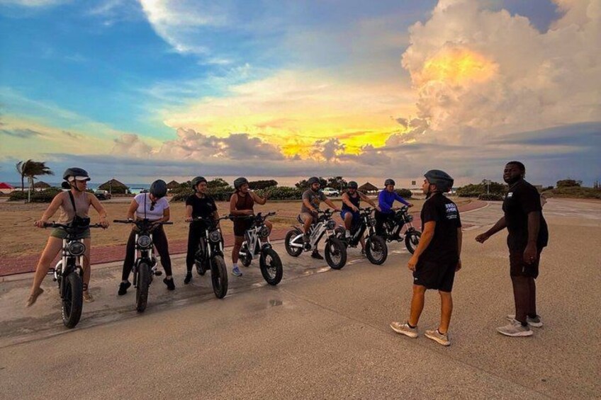 A group of people on motorcycles on a paved road with a sunset in the background. 4