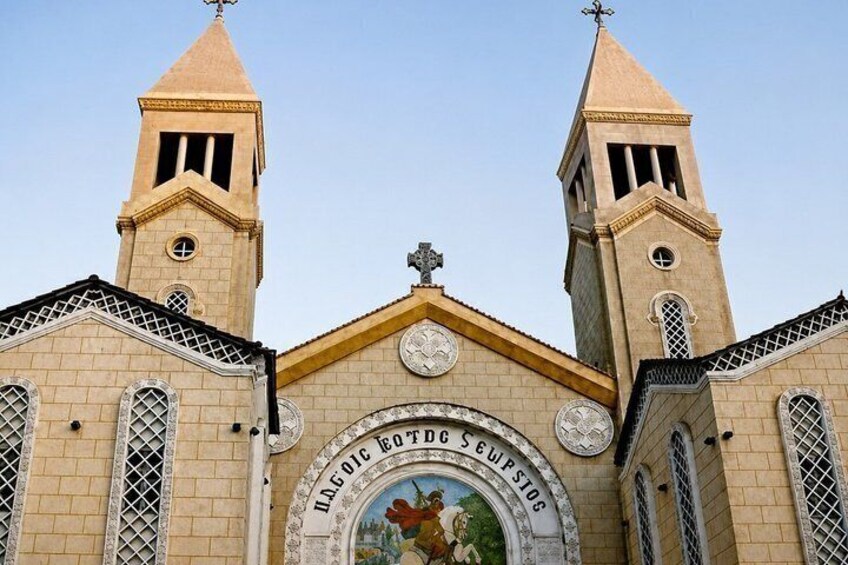 A church with two towers and a central archway with a painting. 2