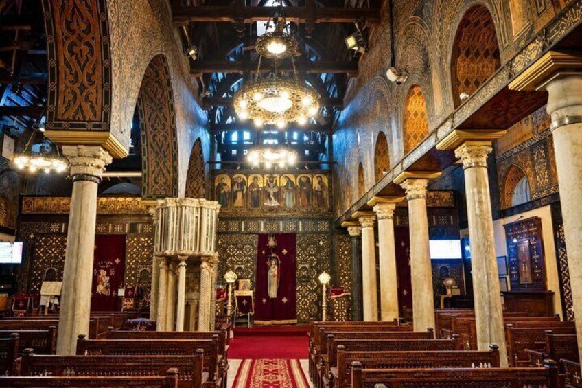An ornate church interior with high ceilings, intricate arches, and a central altar. 3