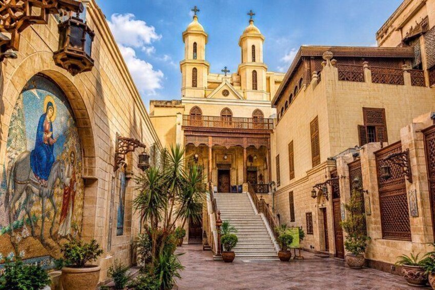 A church with a bell tower, a mosaic, and a staircase leading to the entrance. 1