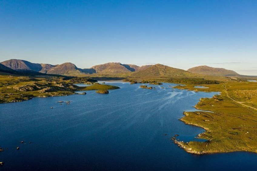 A vast lake surrounded by mountains and grassy terrain. 3