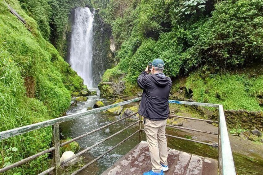 A person taking a photo of a waterfall. 3