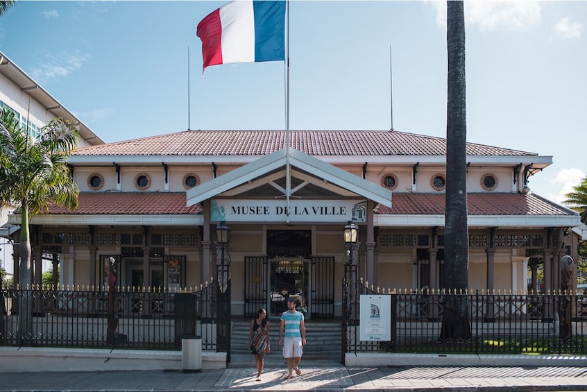 A building with a tiled roof and a flagpole with a flag. 3