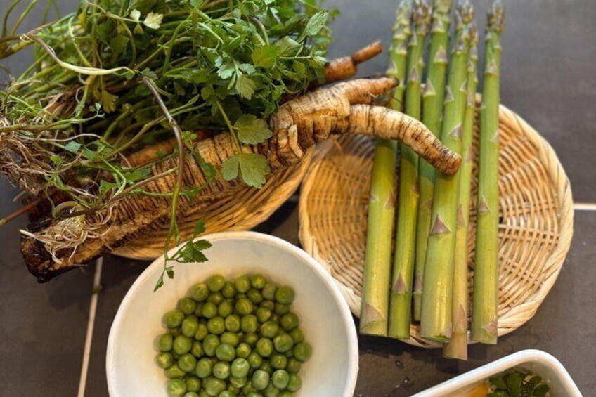 A basket of fresh herbs, asparagus, and peas. 1