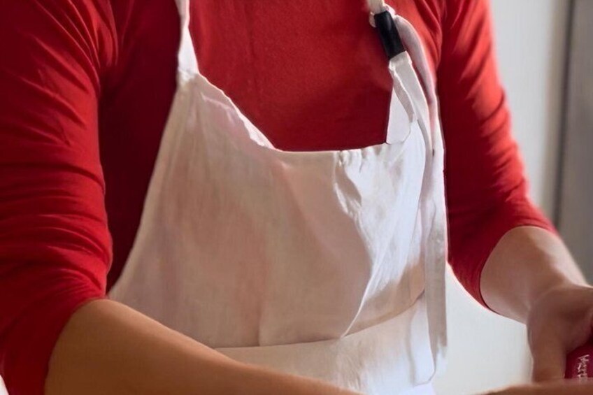 A person wearing a red shirt and a white apron. 5