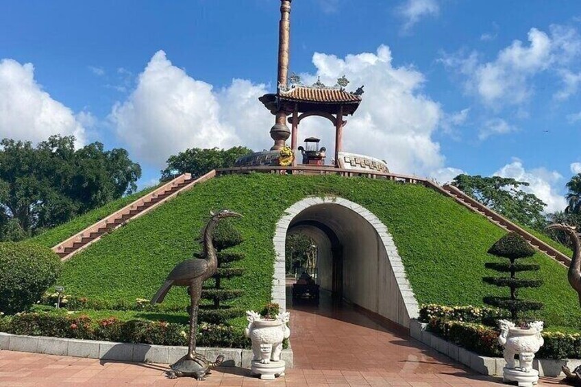 A landscaped pathway leading to a pagoda with a statue of a dragon. 5