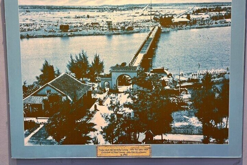 A coastal town with a prominent bridge, waterfront buildings, and a large body of water. 3