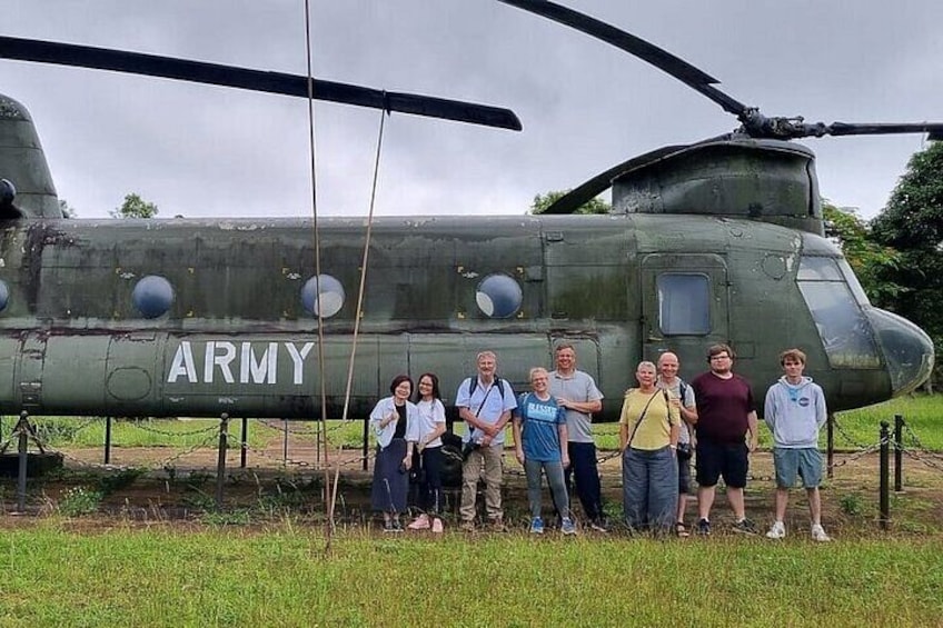 A group of people standing in front of a military helicopter with the word 'ARMY' on it. 1