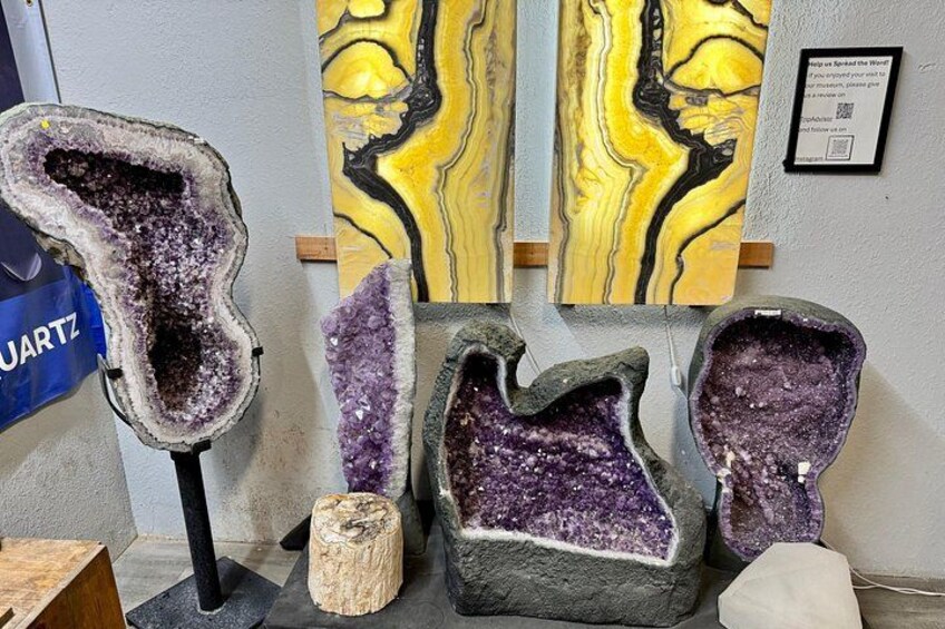 A display of geodes with purple crystals, a marble painting, and a sign about quartz. 2