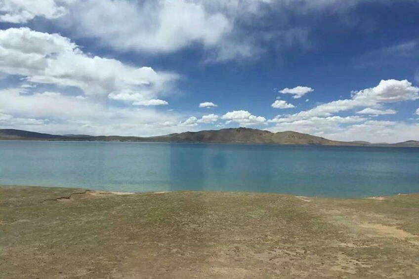 A calm lake with mountains in the background and a clear sky. 2