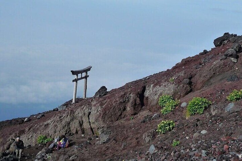 A rocky hillside with a torii gate at the top. 4