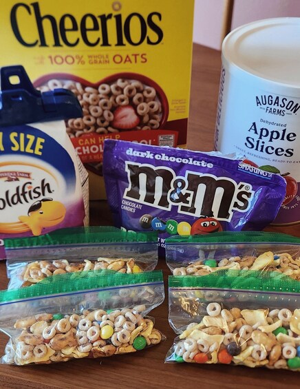 Cheerios, M&M's, Goldfish, and apple slices on a table. 2