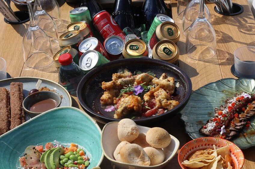 A table with various food items, drinks, and bottles. 3