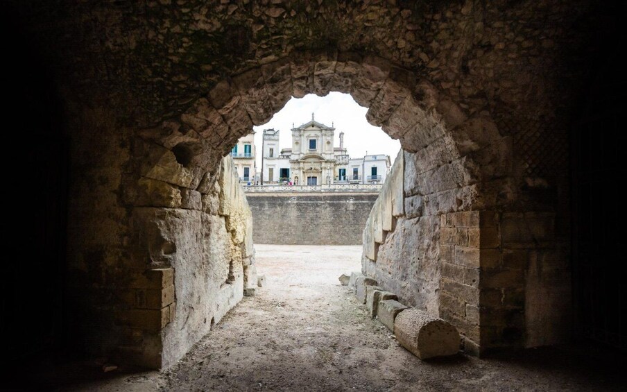 An ancient stone archway leading to a historic building. 1