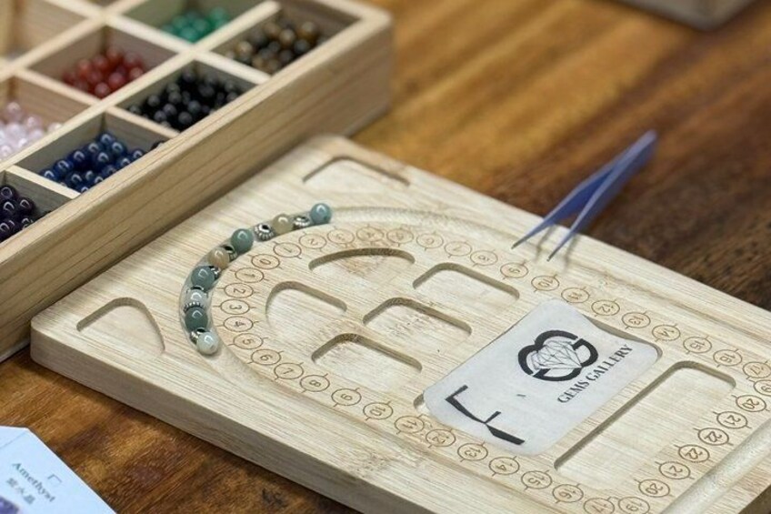 A wooden board with a pegboard, a set of beads, and a card with a logo. 4