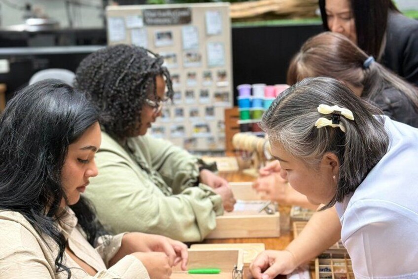 People engaged in a craft activity, possibly knitting or sewing, with various tools and materials visible. 5