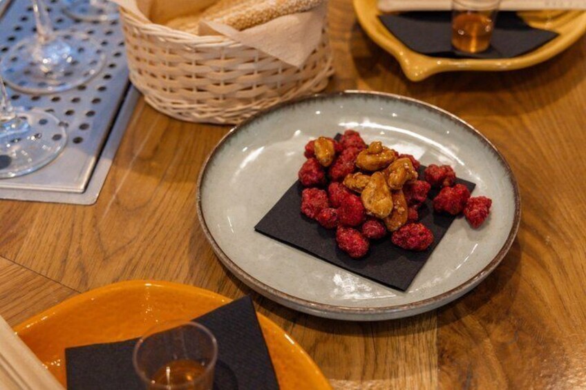 A plate with raspberries and nuts on a ceramic plate. 4