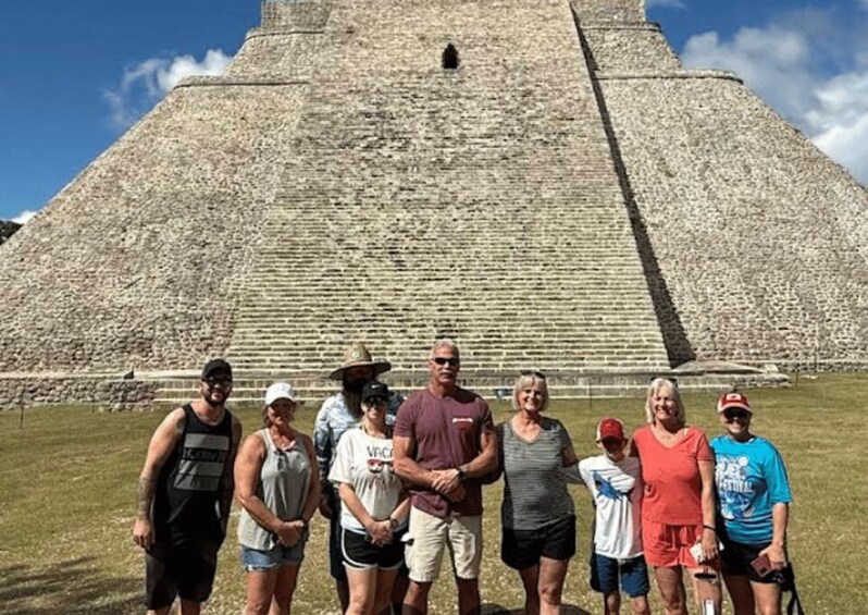 A group of people standing in front of a large pyramid-like structure. 5